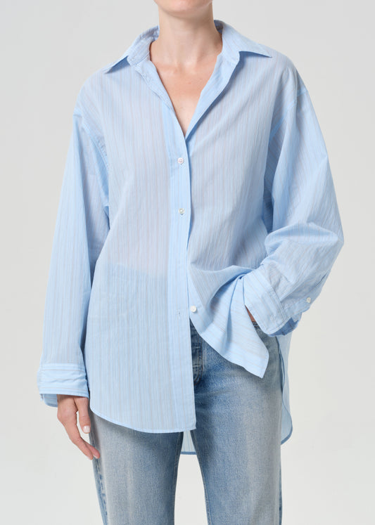 Light blue striped shirt worn by a person on a plain background