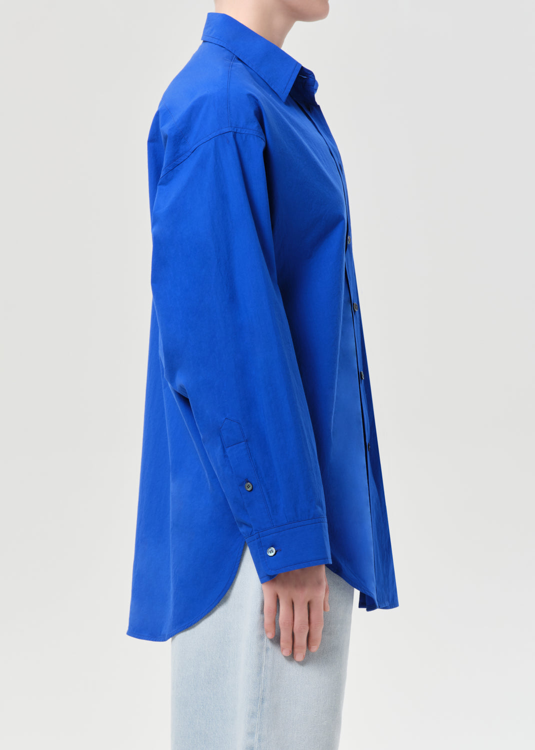 Person wearing a blue shirt on a light gray background