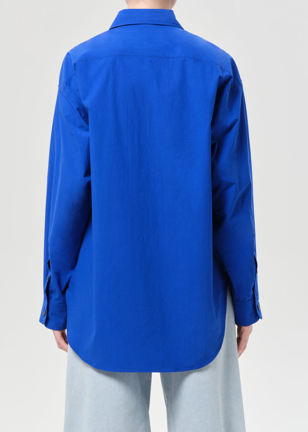 Blue shirt worn by a person on a light gray background