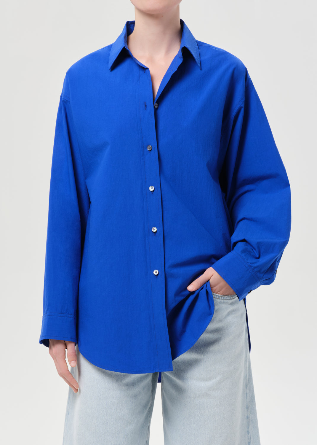Person wearing a blue shirt with a plain background
