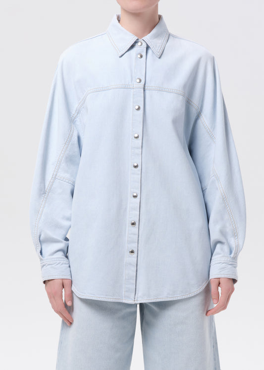 Light blue denim shirt worn by a person on a white background