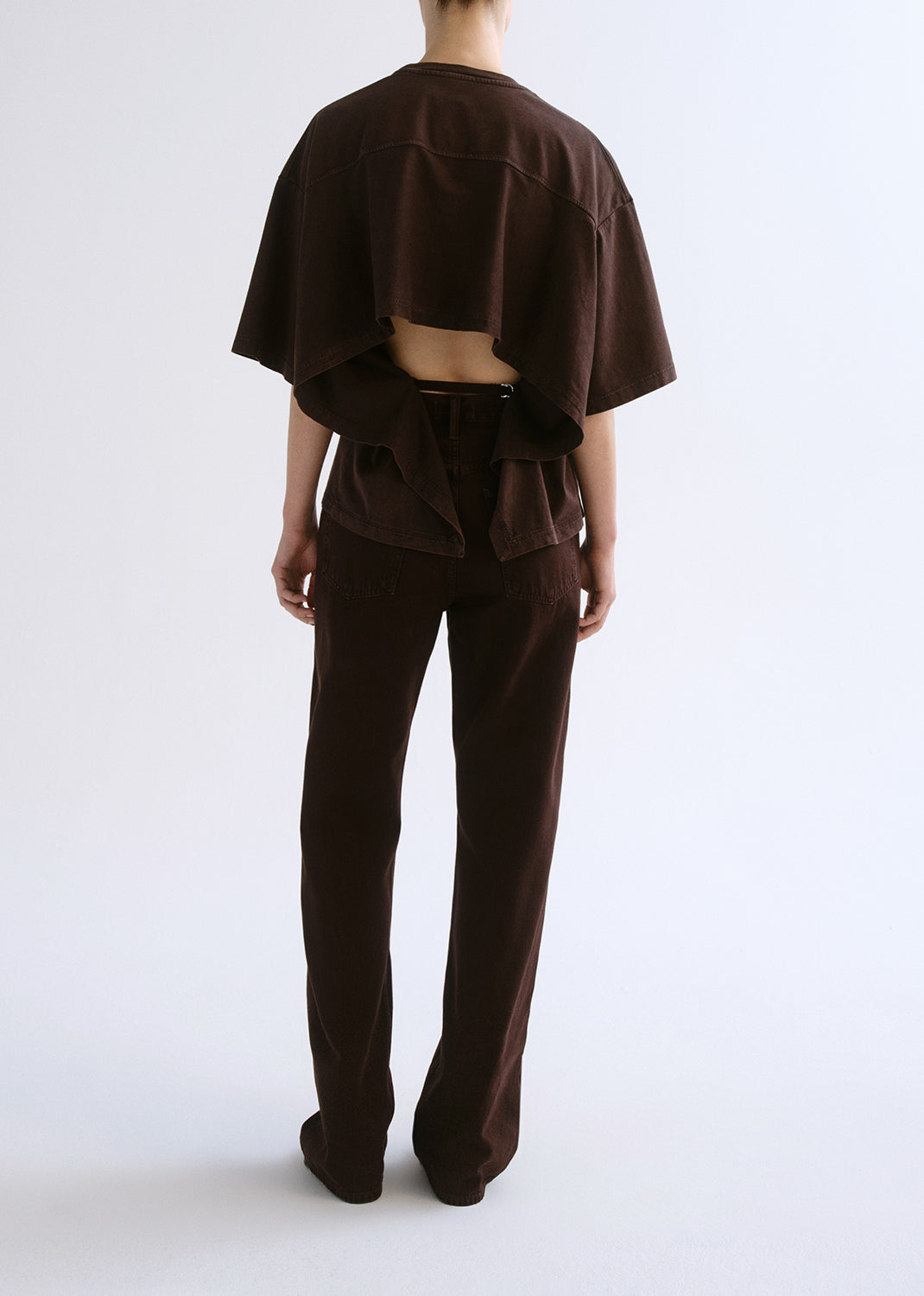Person wearing a brown outfit on a grey background
