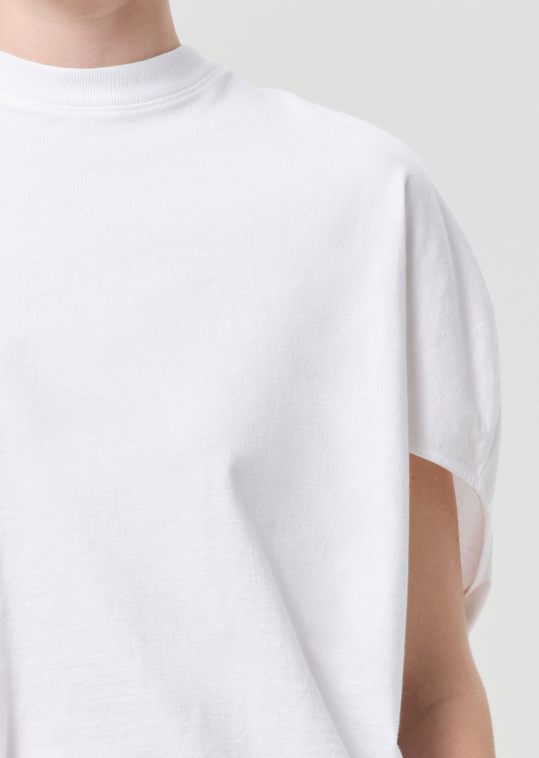 White t-shirt worn by a person on a white background