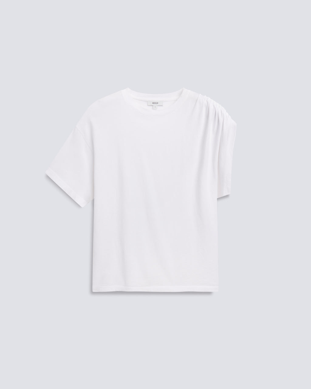 A white short-sleeve t-shirt with a unique draped shoulder detail, displayed flat against a light gray background.