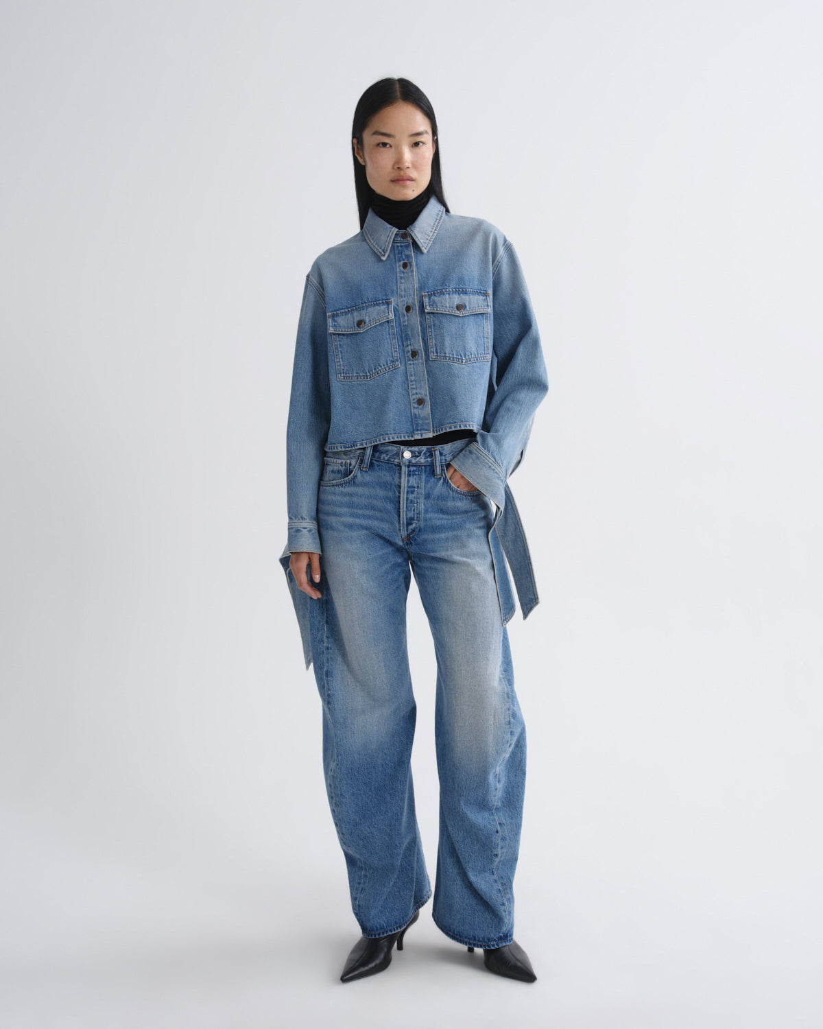 Person wearing a denim outfit on a white background