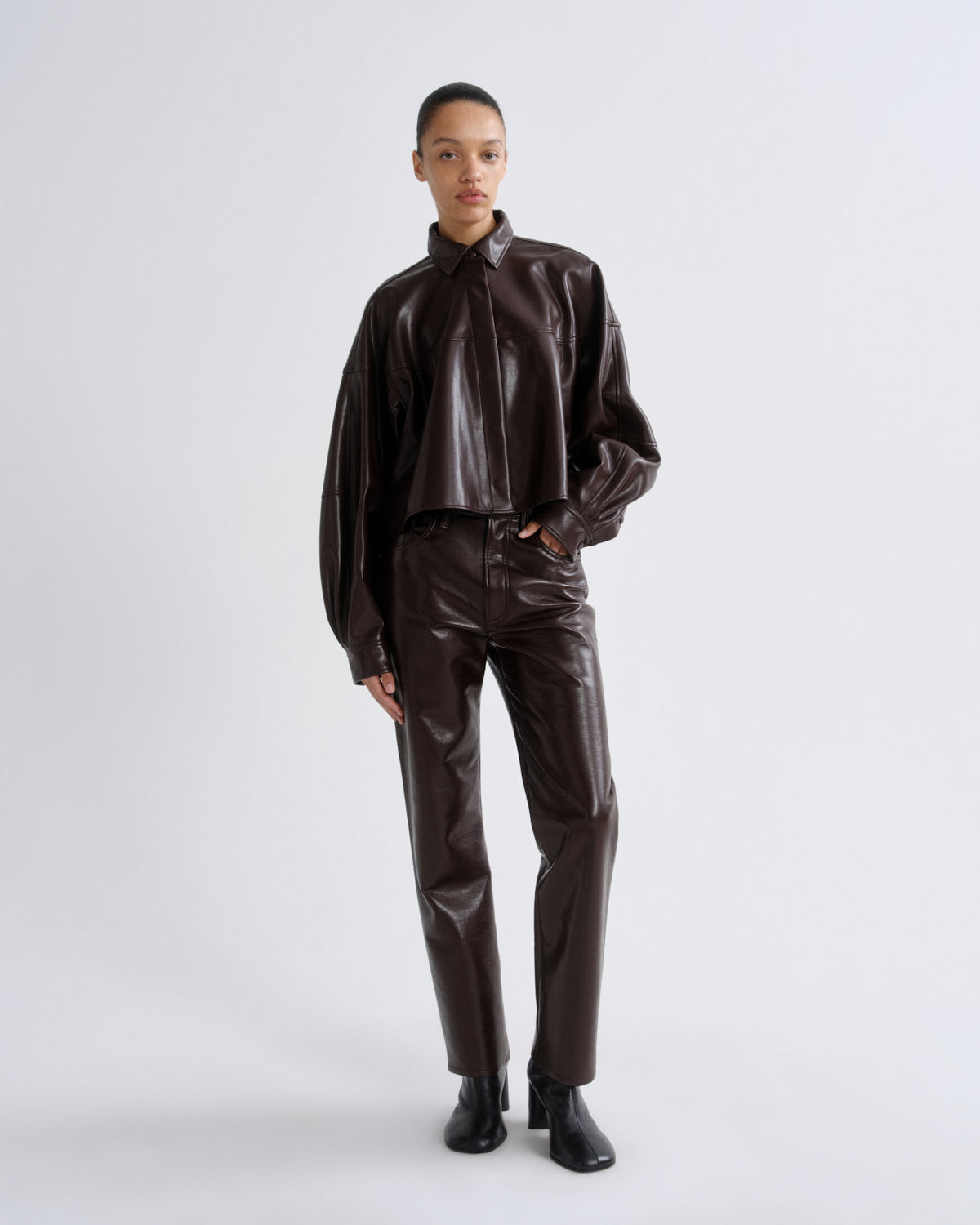Person wearing a brown leather outfit on a white background