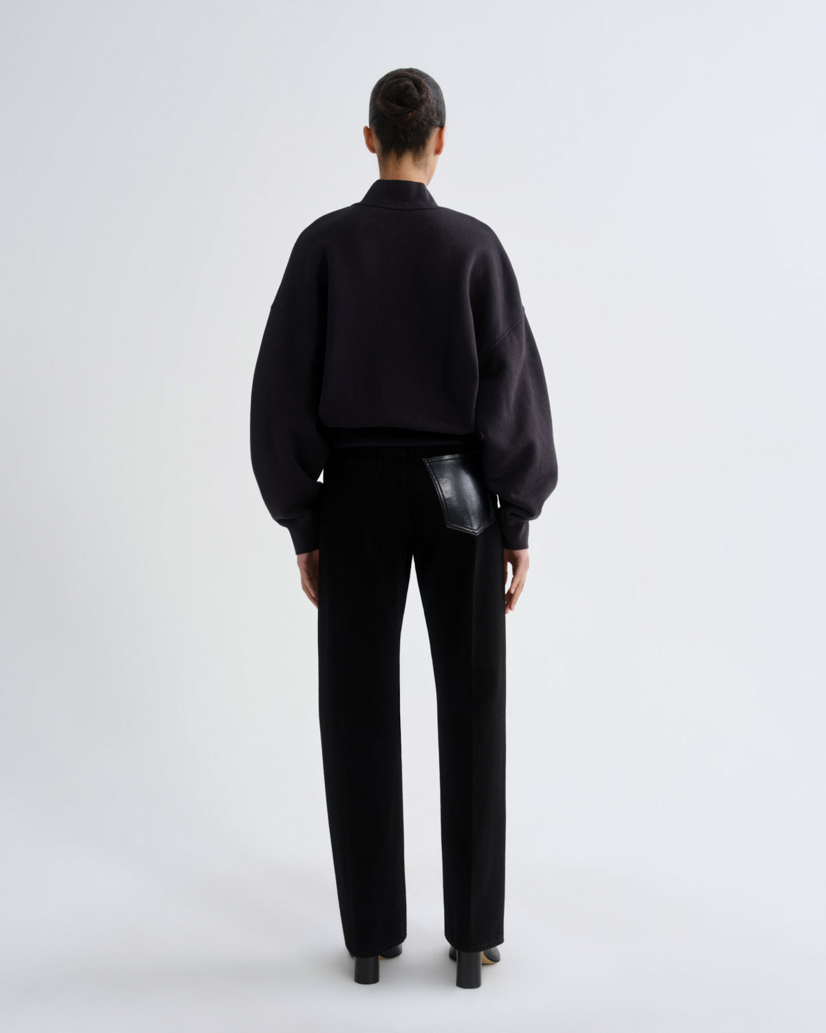 Person wearing a black outfit with a plain white background