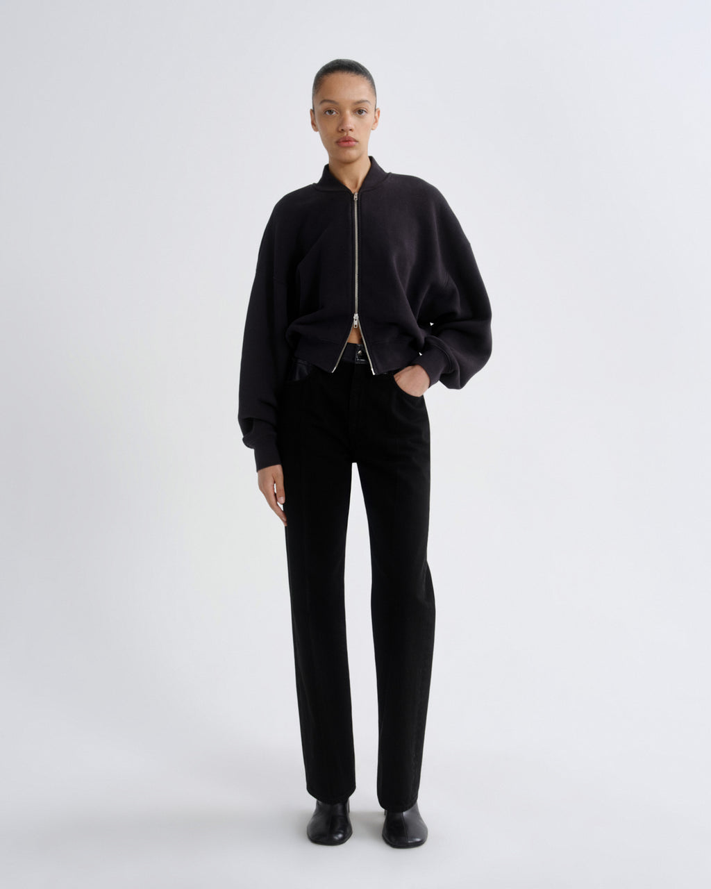 Person wearing a black outfit on a white background