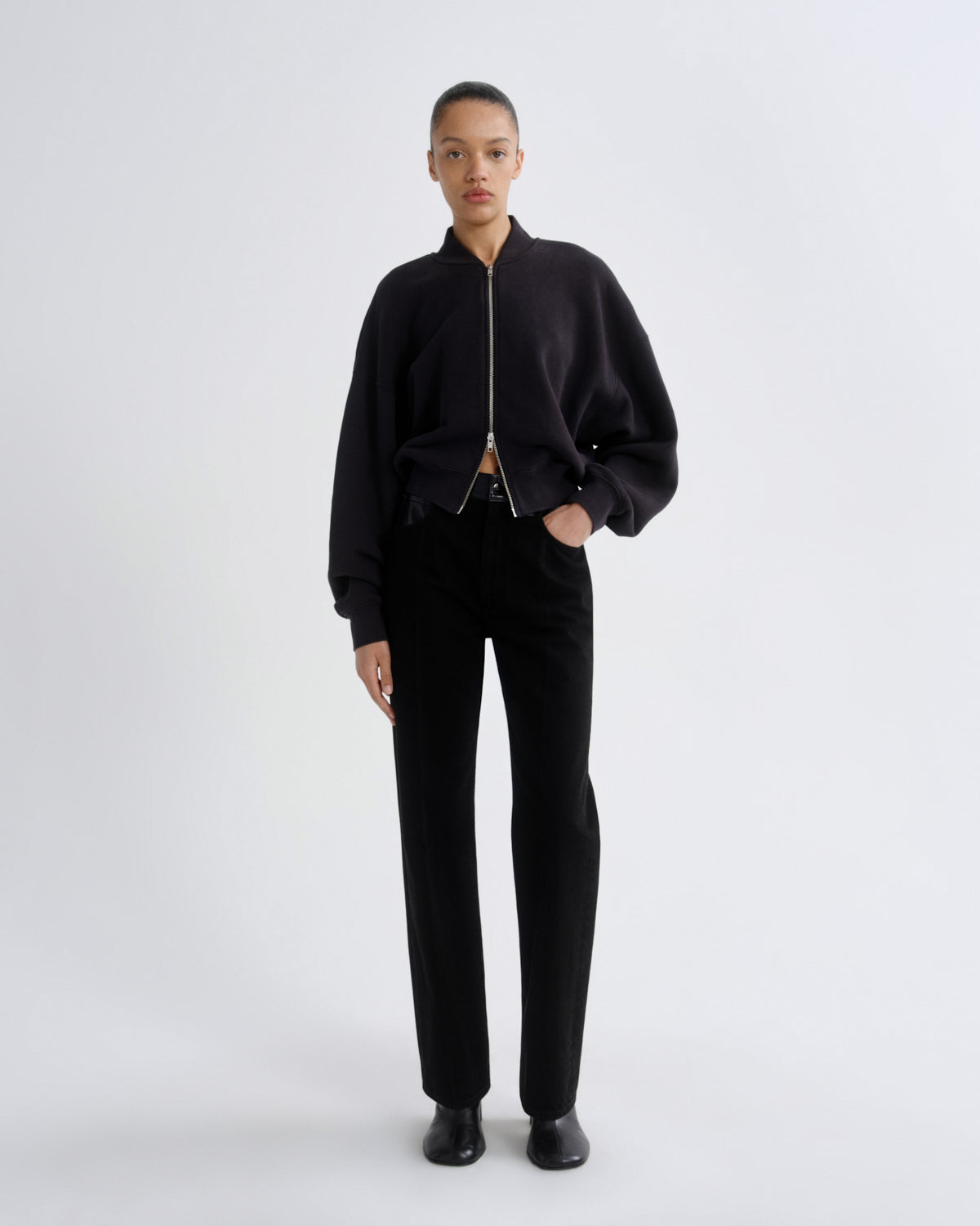 Person wearing a black outfit on a white background