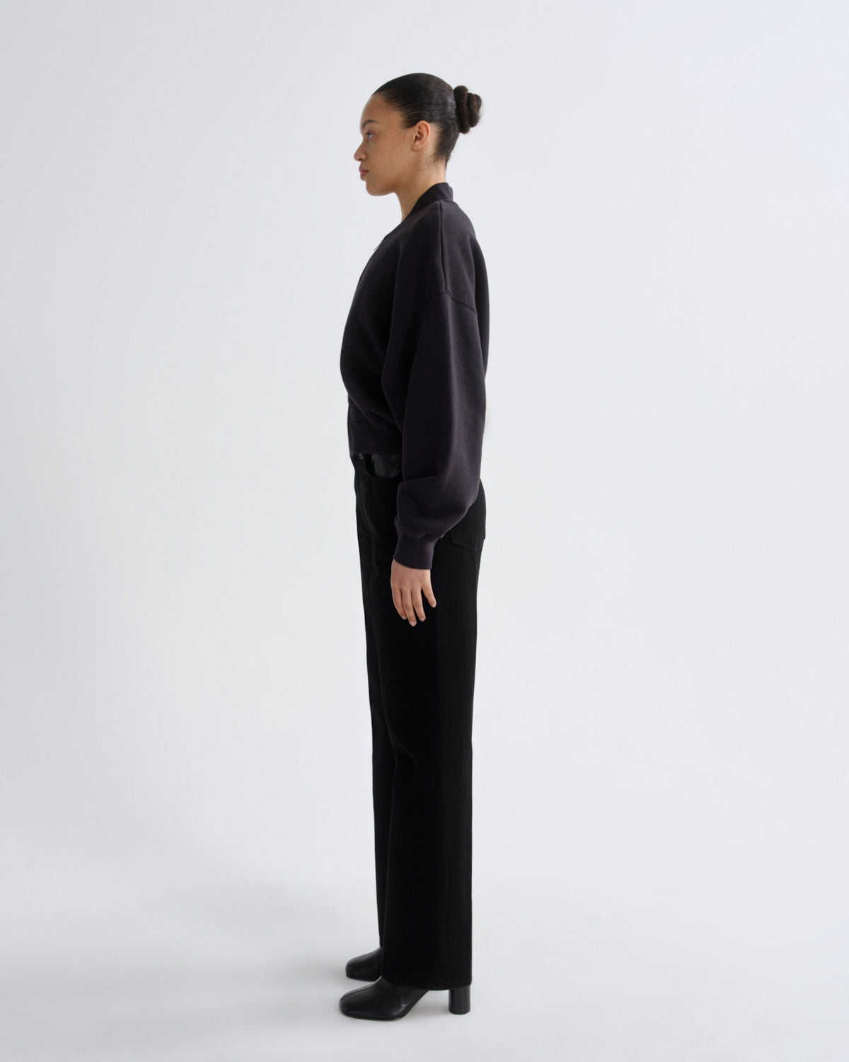 Person wearing a black outfit on a white background