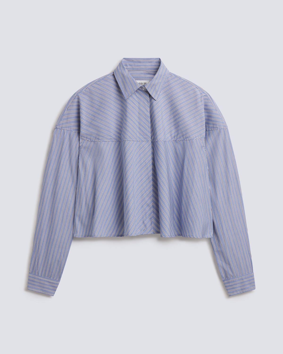 A cropped long-sleeve button-up shirt with a blue and white vertical stripe pattern, featuring a structured collar and a unique horizontal seam design across the chest and shoulders, displayed on a light gray background.