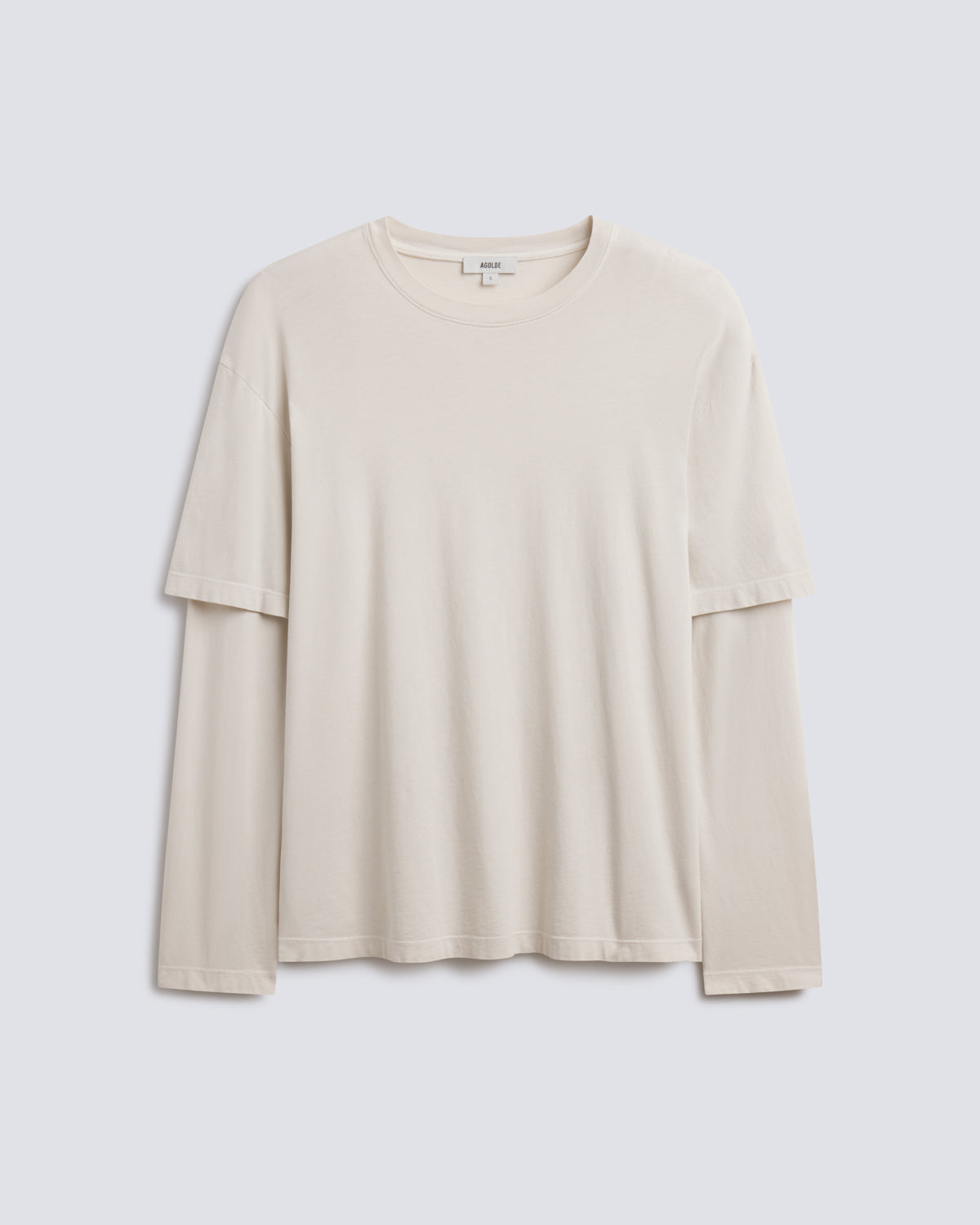 A light beige long-sleeve t-shirt with a relaxed fit, displayed flat against a light gray background.