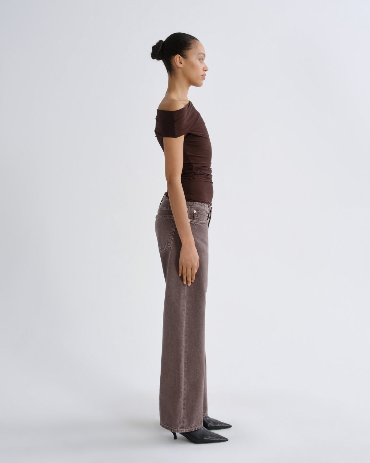 Woman wearing a brown top and wide-leg pants on a white background