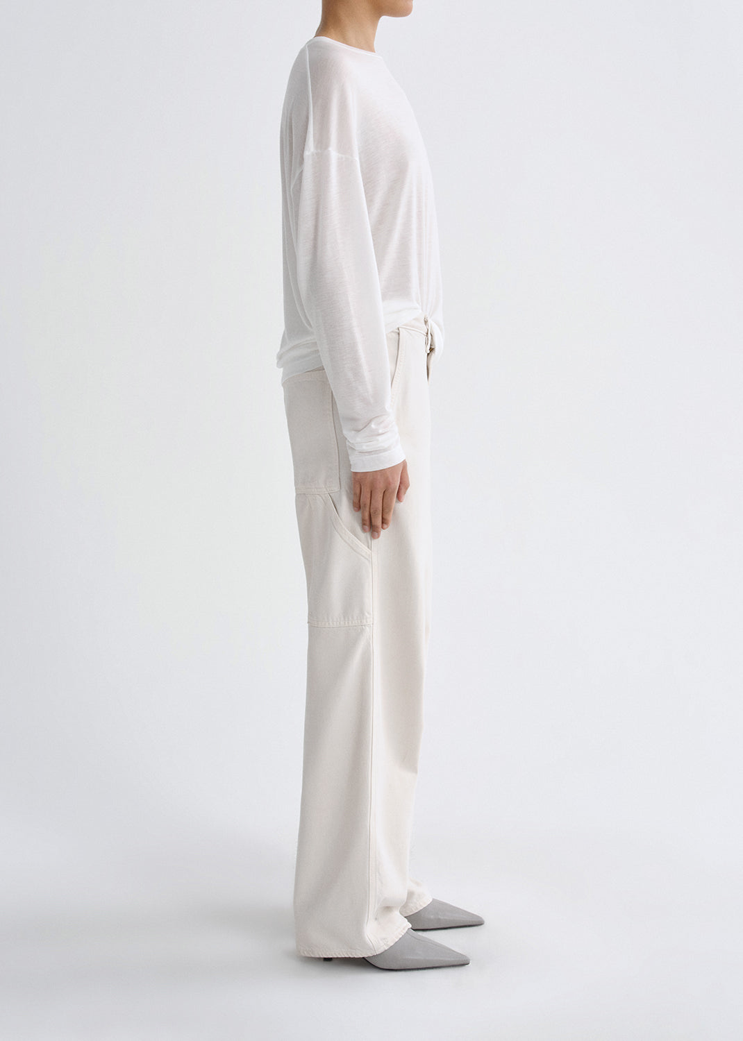 Person wearing a white outfit on a grey background