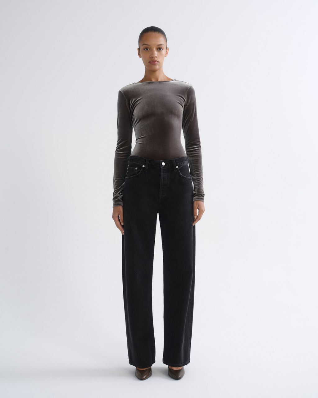Person wearing brown long sleeve bodysuit and black jeans, alternate front view