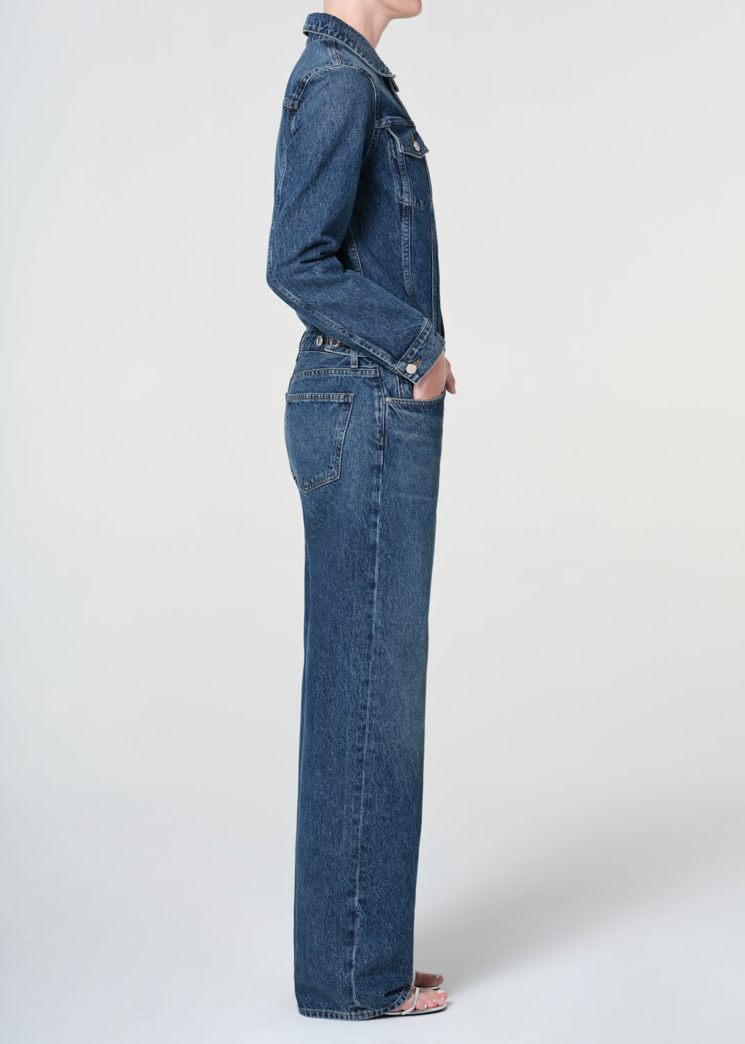 Person wearing a blue denim outfit on a white background