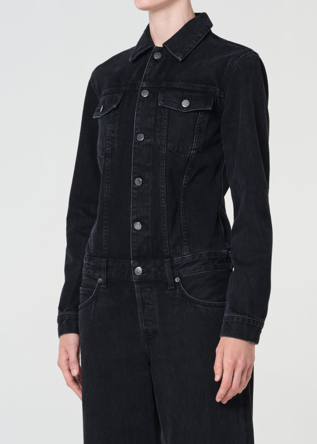 Black denim jacket worn by a person on a white background