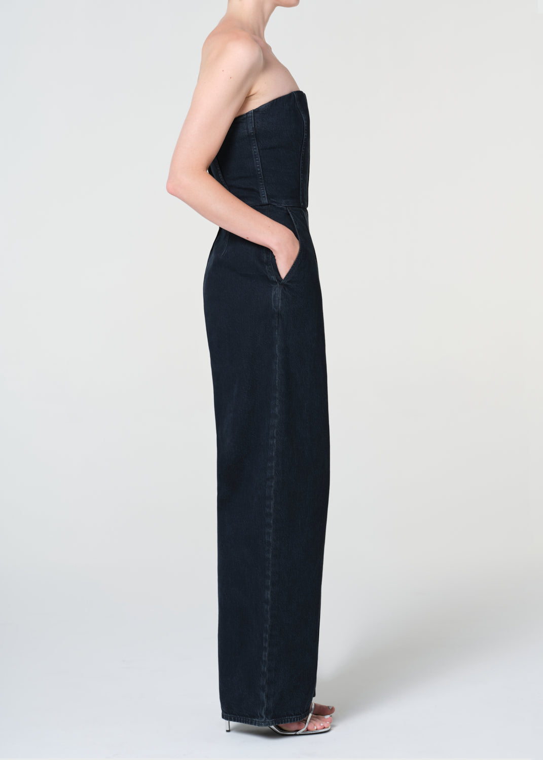 Black strapless jumpsuit worn by a model on a white background