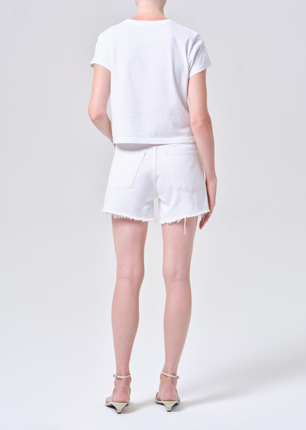 Person wearing a white outfit on a plain background