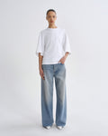 Person wearing a white t-shirt and light blue jeans on a white background