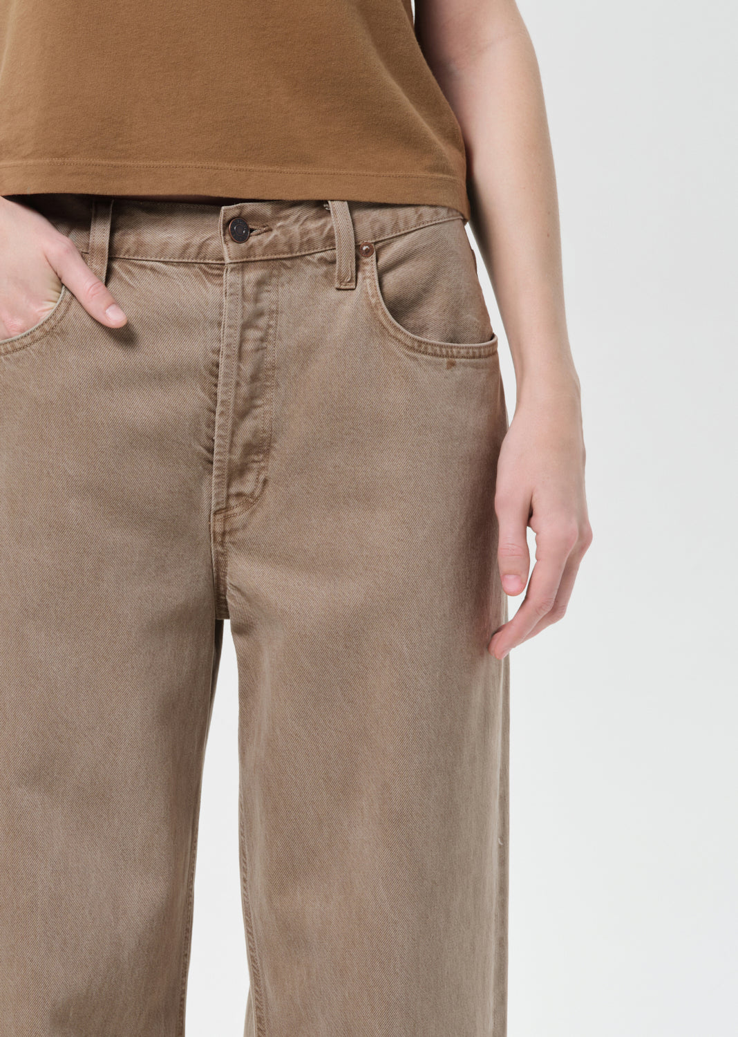 Brown pants worn by a person on a white background