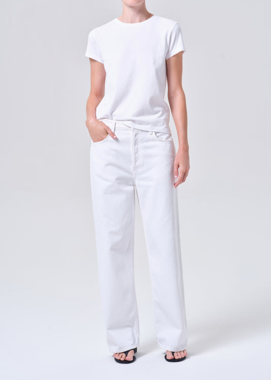 Person wearing a white t-shirt and white pants on a plain background