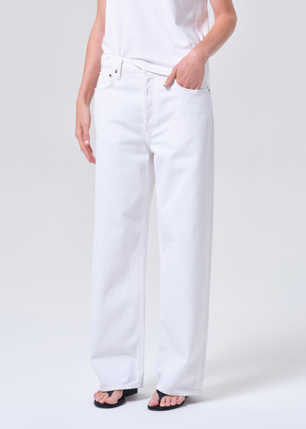 Person wearing white pants on a plain background