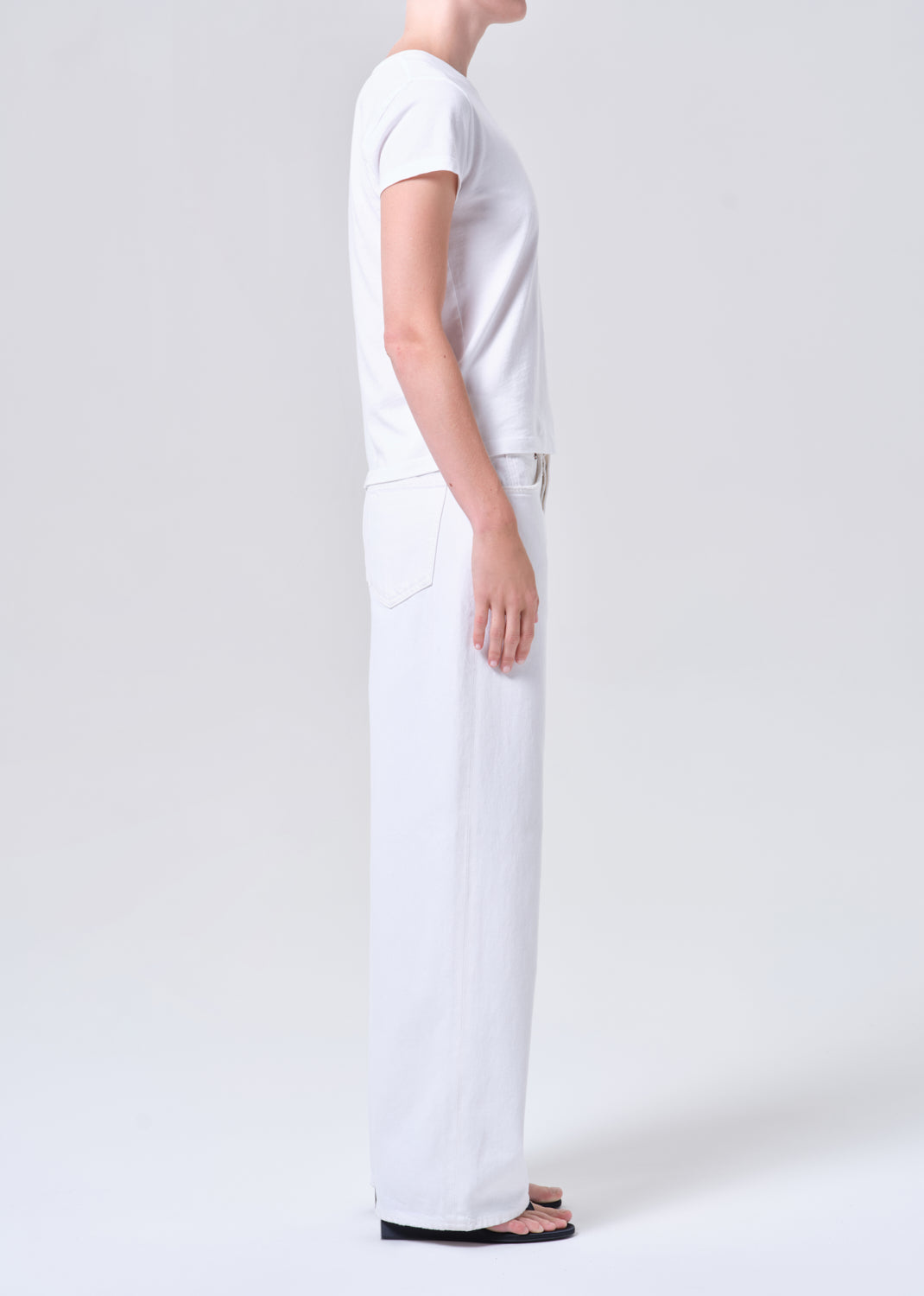 Person wearing a white outfit on a plain background