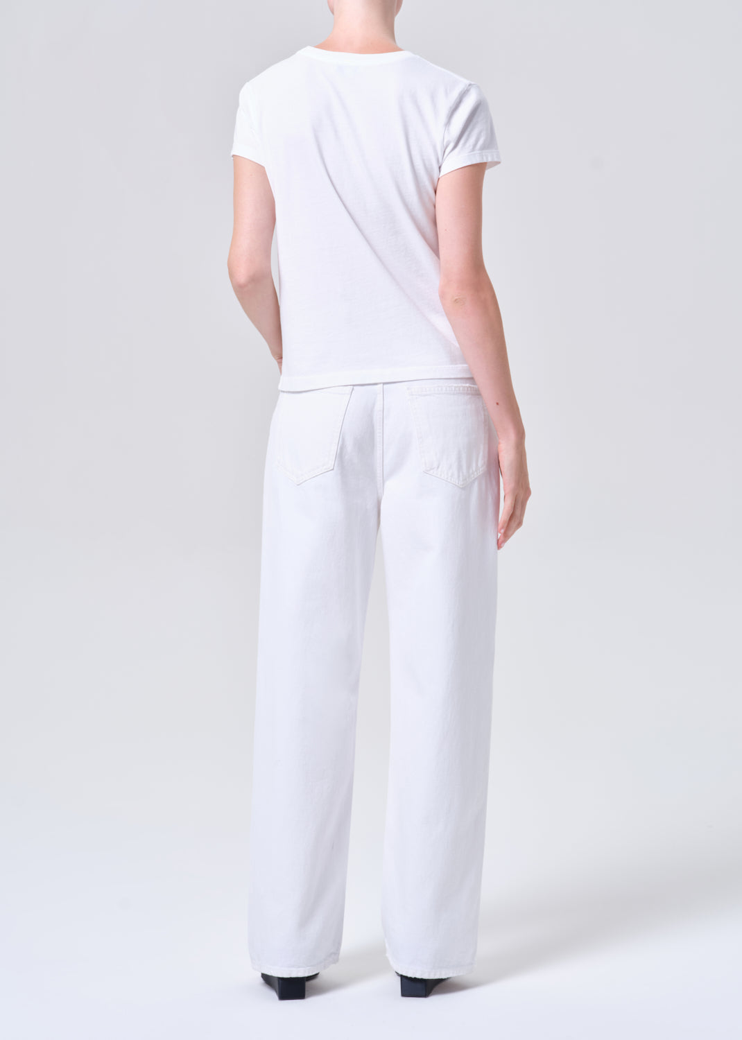 Person wearing a white outfit on a plain background