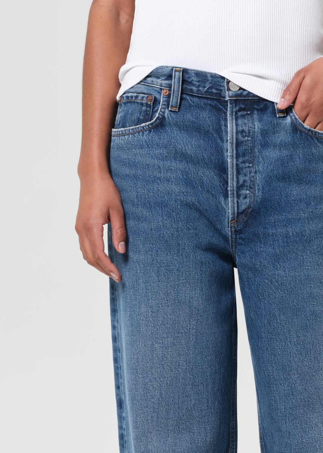 Blue jeans worn by a person on a light gray background
