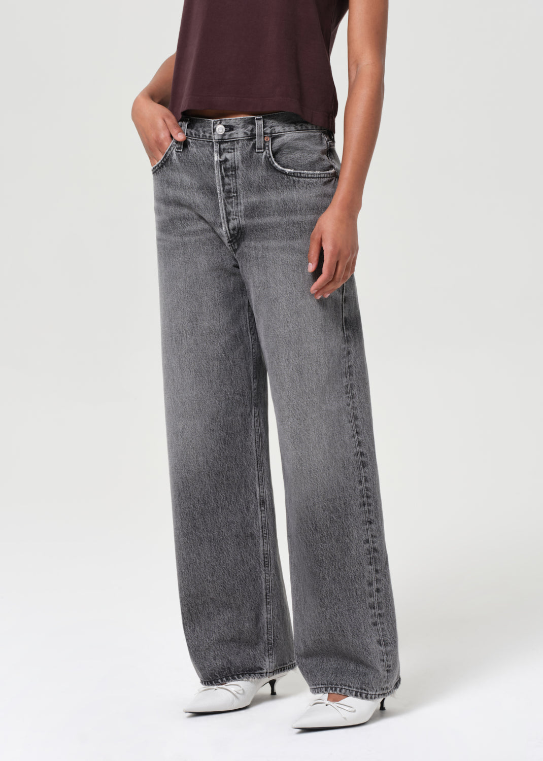Person wearing gray wide-leg jeans on a white background
