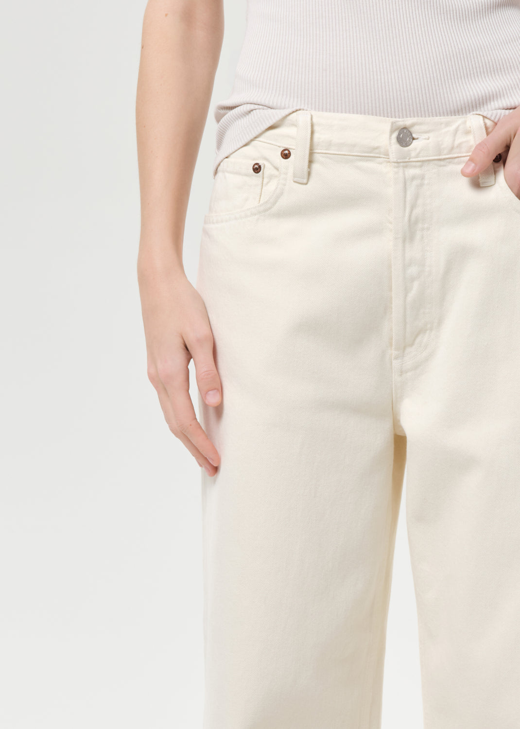 White jeans worn by a person on a light gray background