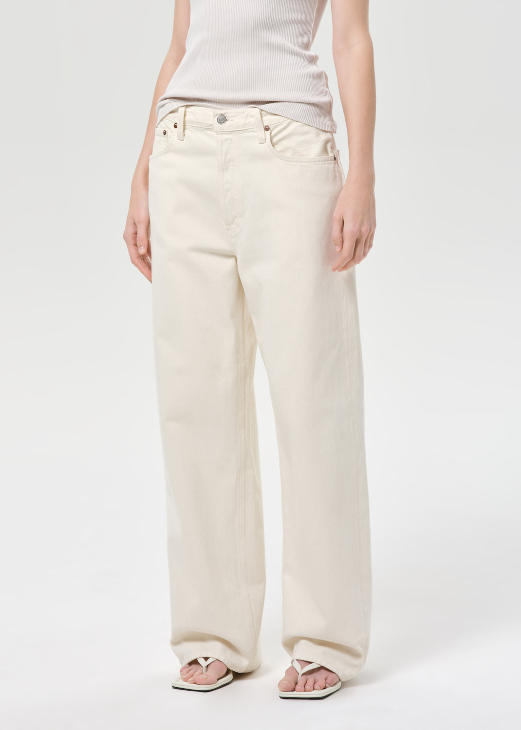 Person wearing white wide-leg jeans on a plain background