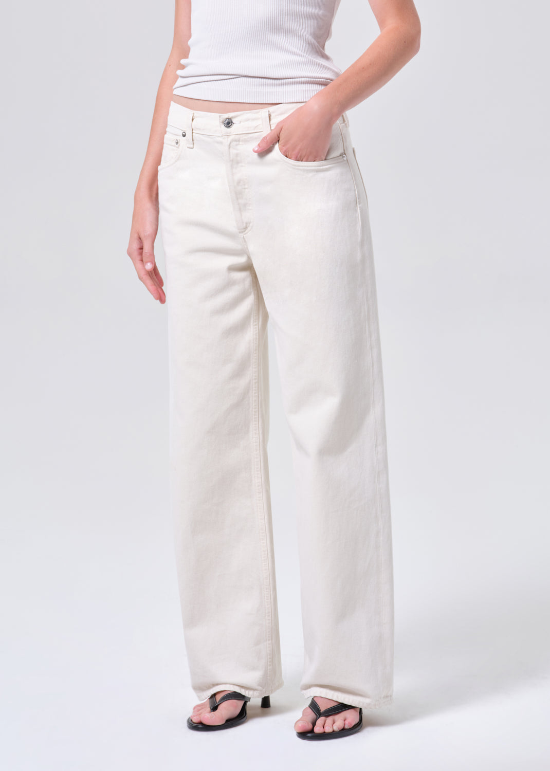 Person wearing white wide-leg jeans on a plain background