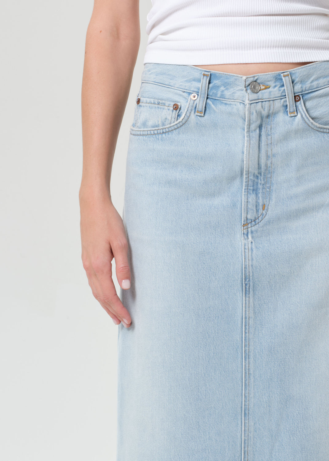 Light blue denim skirt worn by a person on a plain background