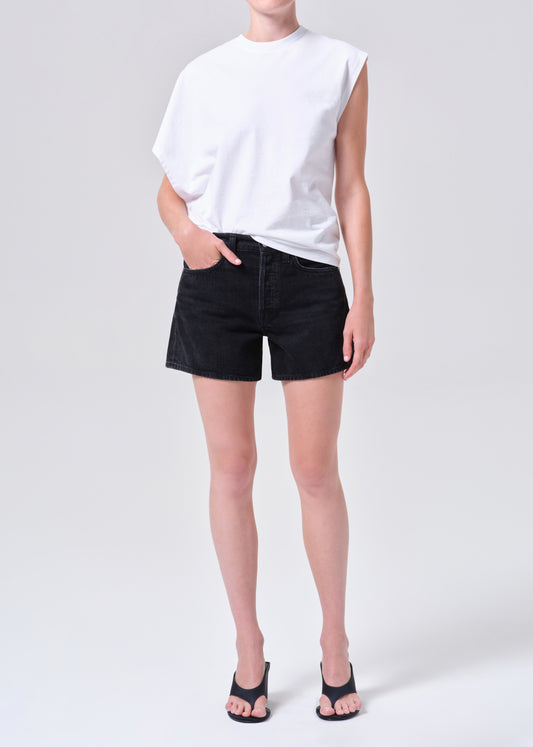 Person wearing a white t-shirt and black shorts on a plain background