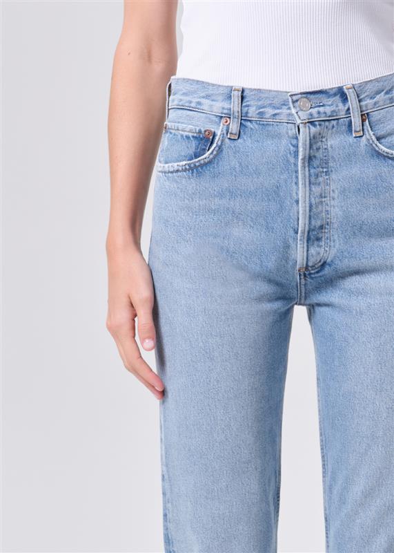 Light blue jeans worn by a person on a light gray background