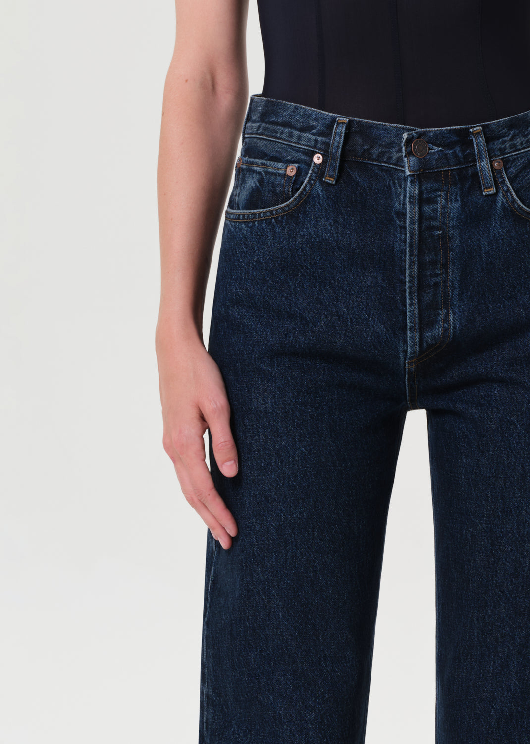 Close-up of dark blue jeans on a plain background