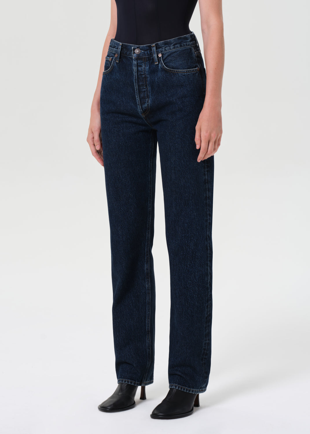Person wearing dark blue jeans on a white background