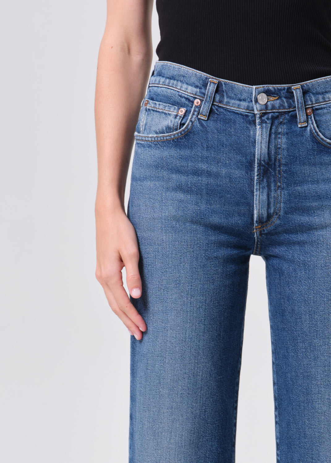 Blue jeans worn by a person on a light gray background