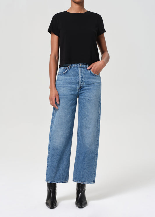 Person wearing a black t-shirt and blue jeans on a white background