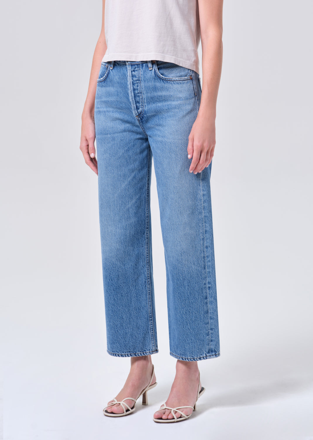 Person wearing light blue jeans on a white background