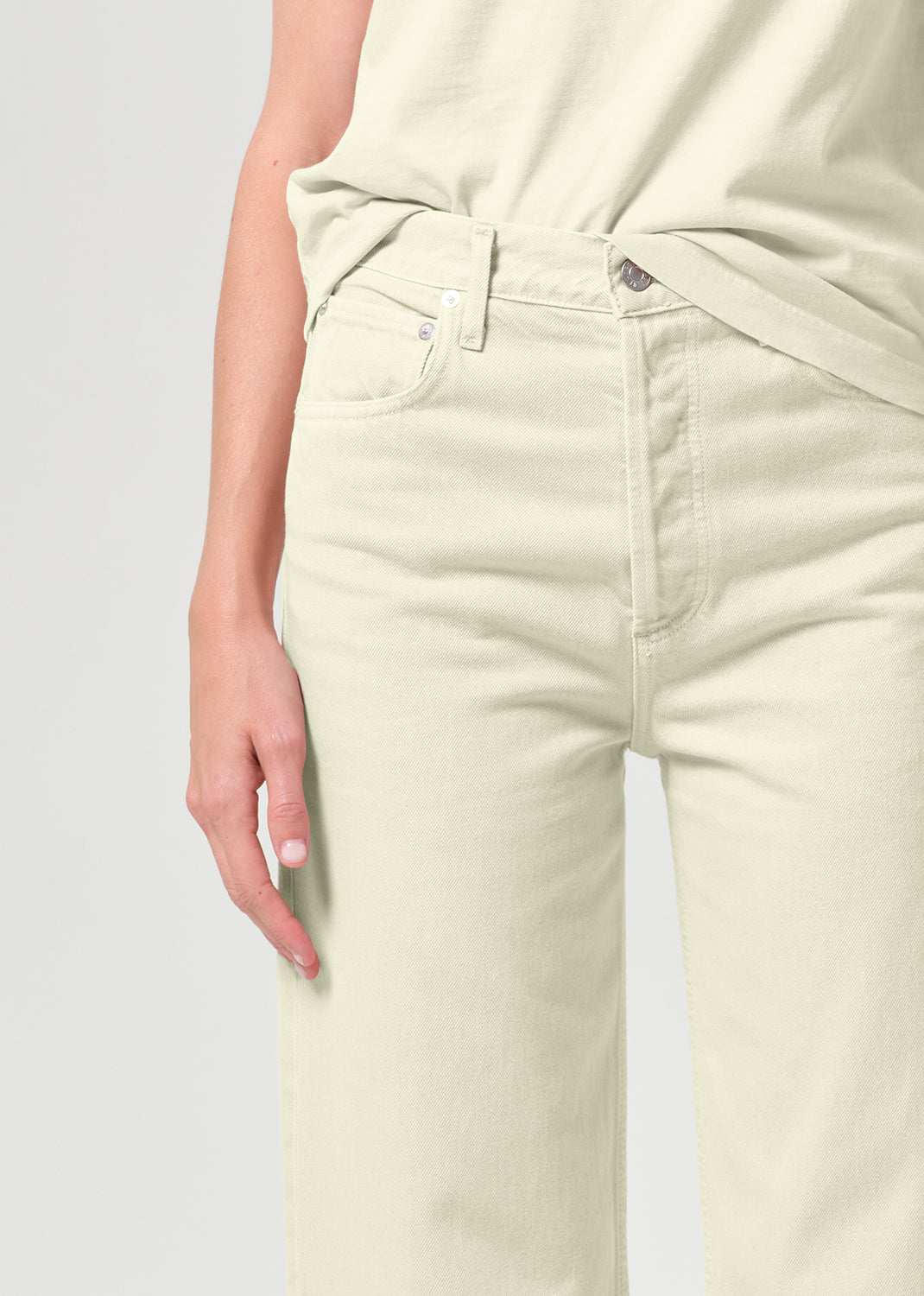 Light-colored pants worn by a person on a light gray background