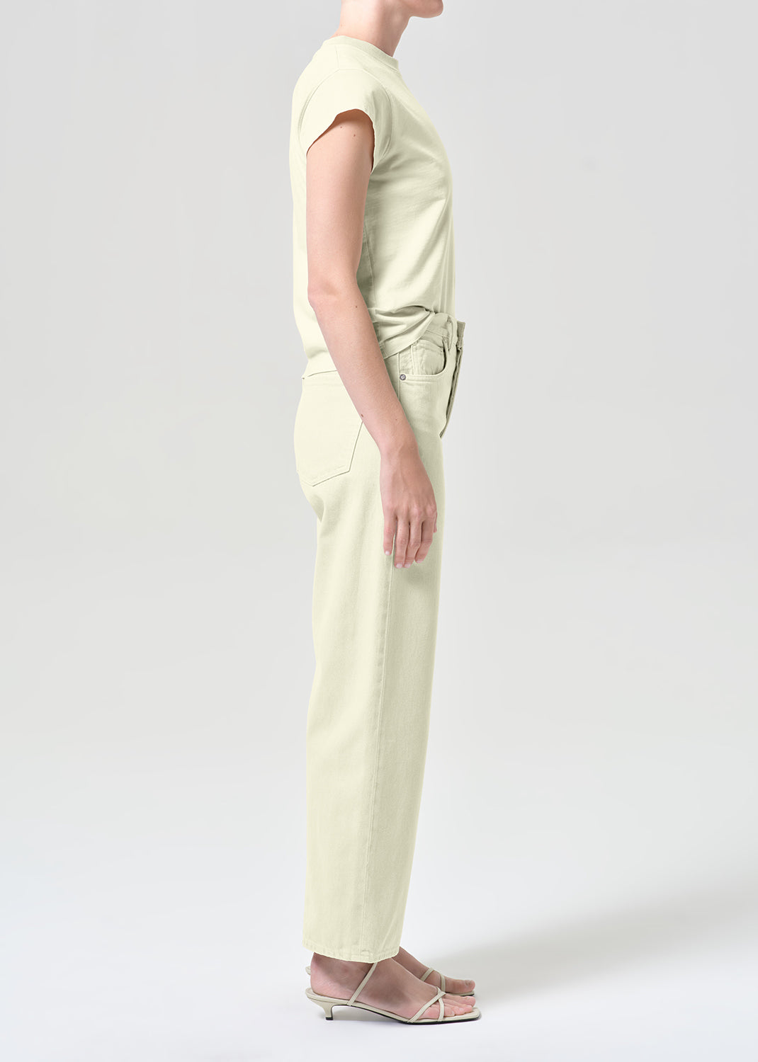 Person wearing a light green jumpsuit on a white background