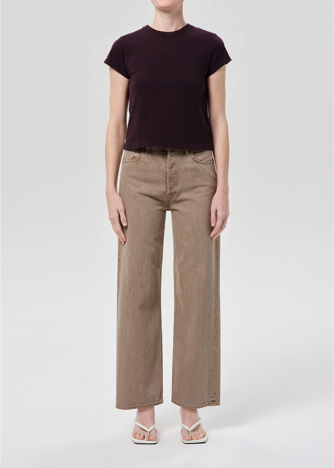 Person wearing purple top and brown jeans