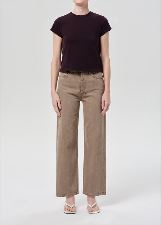 Person wearing purple top and brown jeans