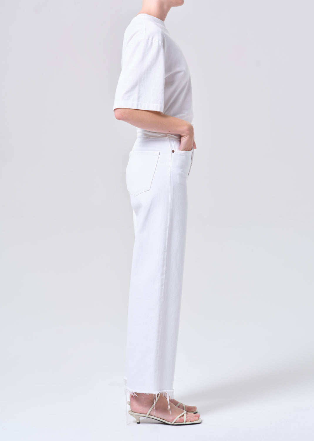 Person wearing a white outfit with a plain background