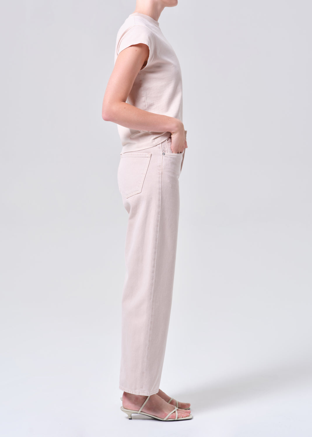 Person wearing a light pink outfit on a white background