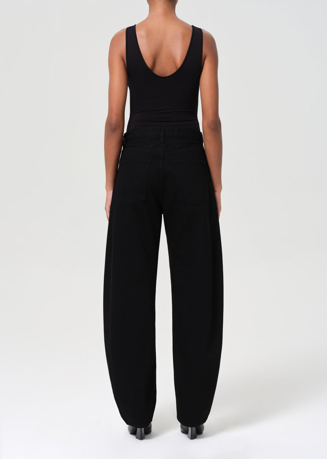 Person wearing a black jumpsuit on a white background