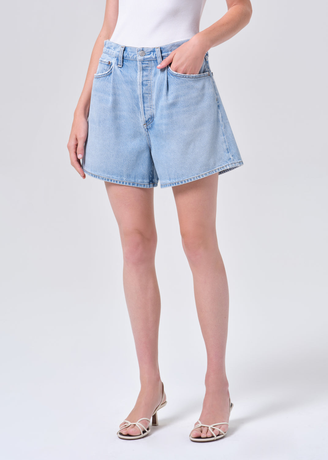 Light blue denim shorts worn by a person on a white background